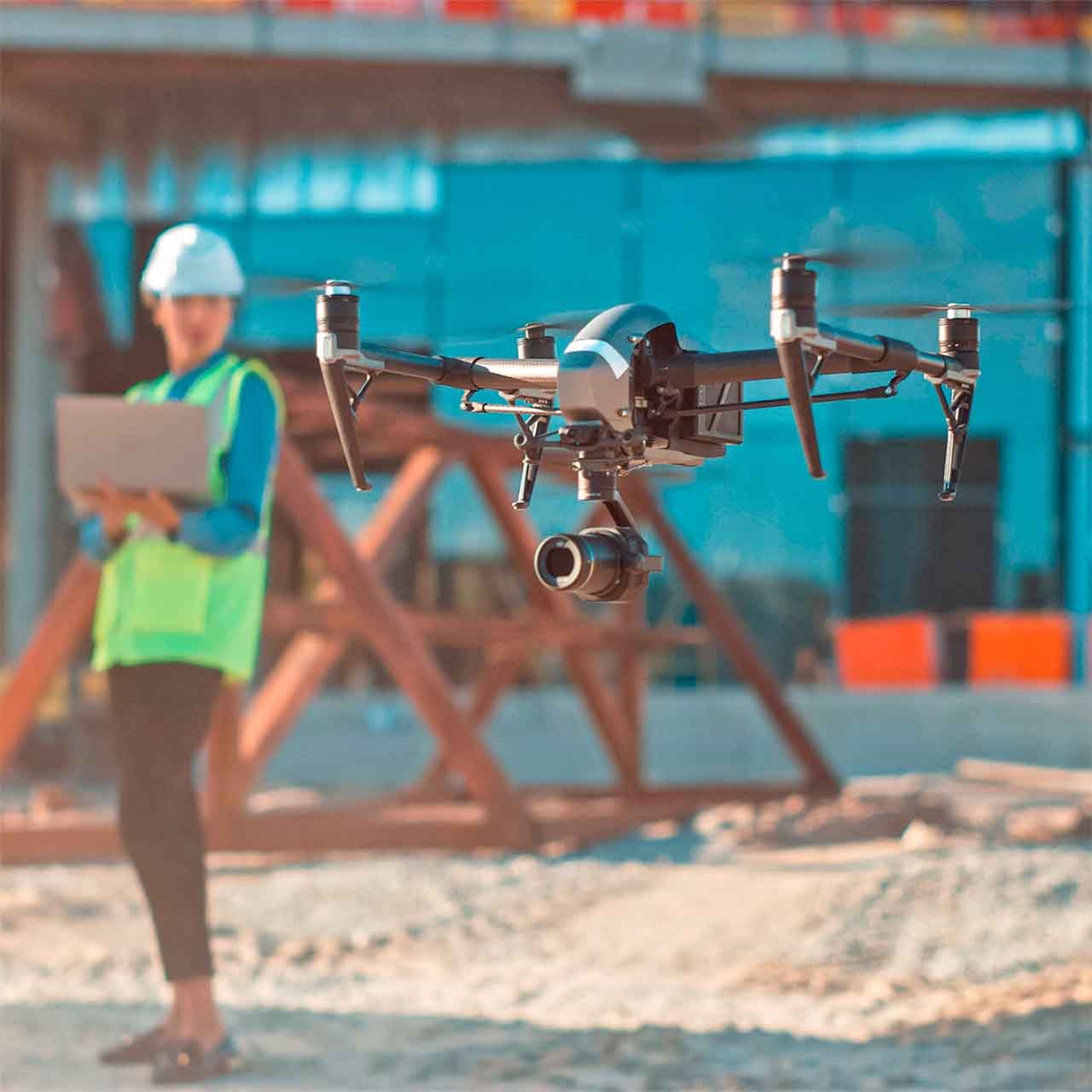 Photo illustrant les nouveautés en location, avec un drone en vol stationnaire sur un chantier et un ouvrier en arrière-plan.