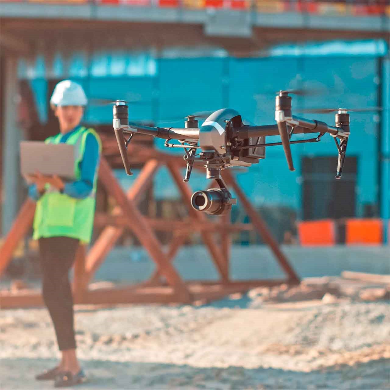 Photo illustrant les nouveautés en location, avec un drone en vol stationnaire sur un chantier et un ouvrier en arrière-plan.