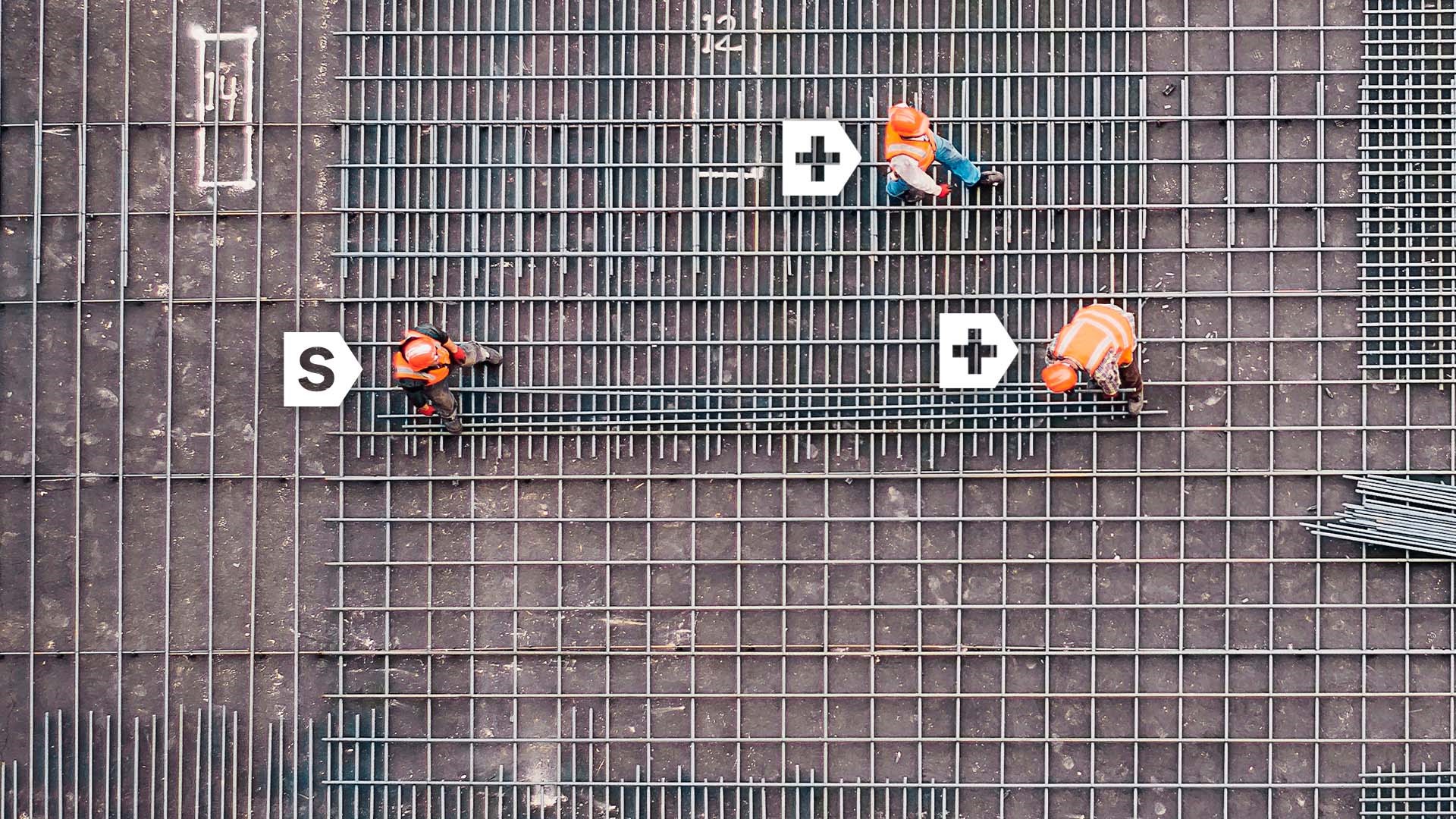 3 travailleurs dans un chantier de construction, vue de haut en bas, logos Simplex visants chaque travailleur et un symbole "+" sur 2 des travailleurs.